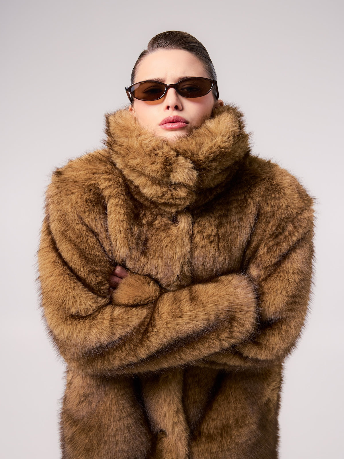 AUDREY jacket in Bronde — model wearing a vegan faux fur jacket with a rich natural-tone finish, styled with a coordinating faux fur scarf and slim sunglasses for a refined cold-weather look.