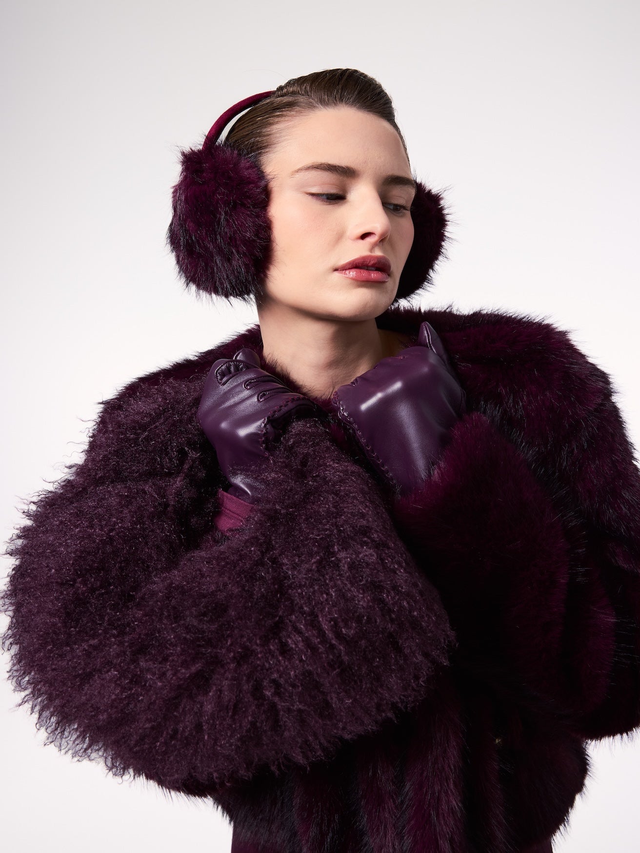 Model wearing plush vegan faux fur styled with matching plum faux fur outerwear and coordinating gloves for a refined cold-weather look.