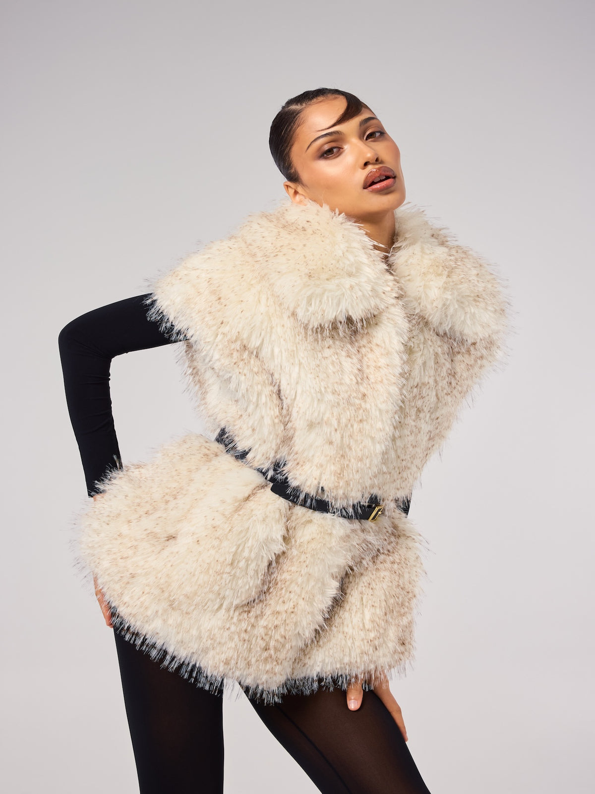 MIA vest in Pebble — model wearing a belted vegan faux fur vest with a soft speckled finish and oversized collar, styled over a fitted black base layer for an elevated editorial look.
