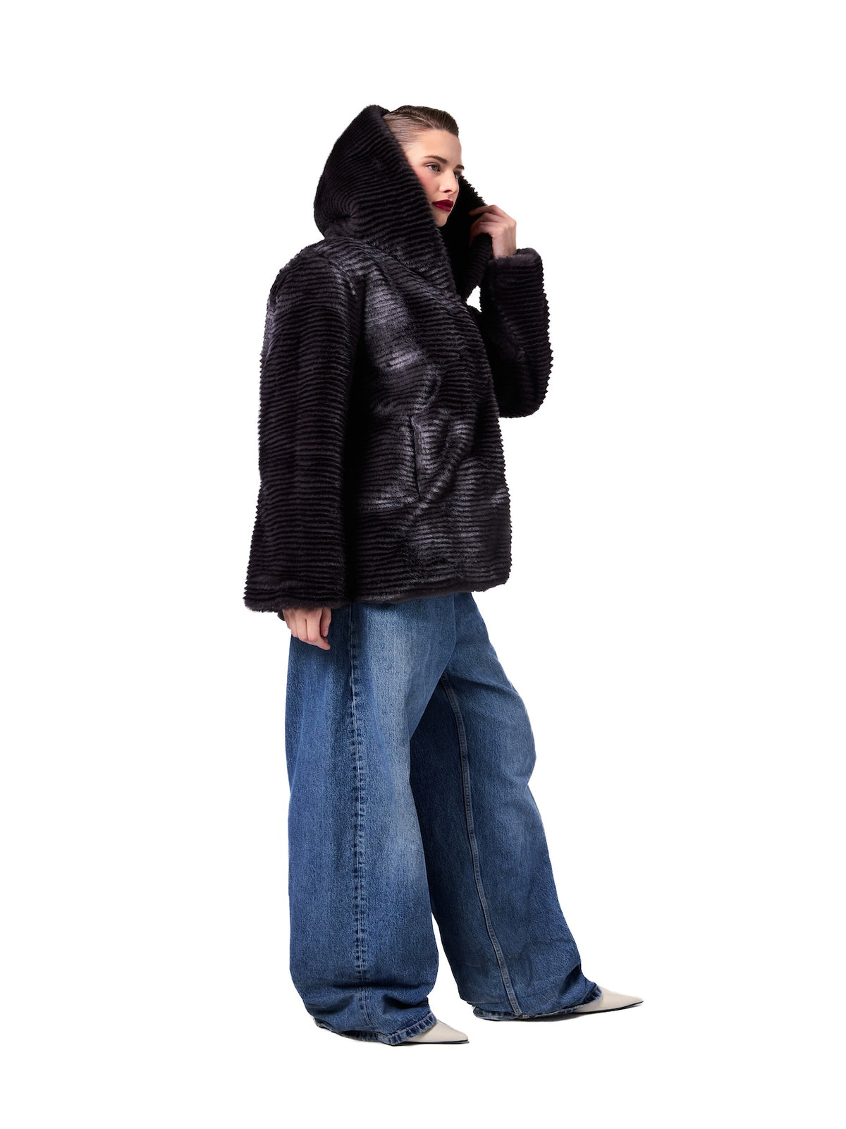 NIKI jacket in Shadow Stripe — side profile showcasing the plush faux fur texture, oversized hood, relaxed silhouette, and contemporary luxury outerwear design.
