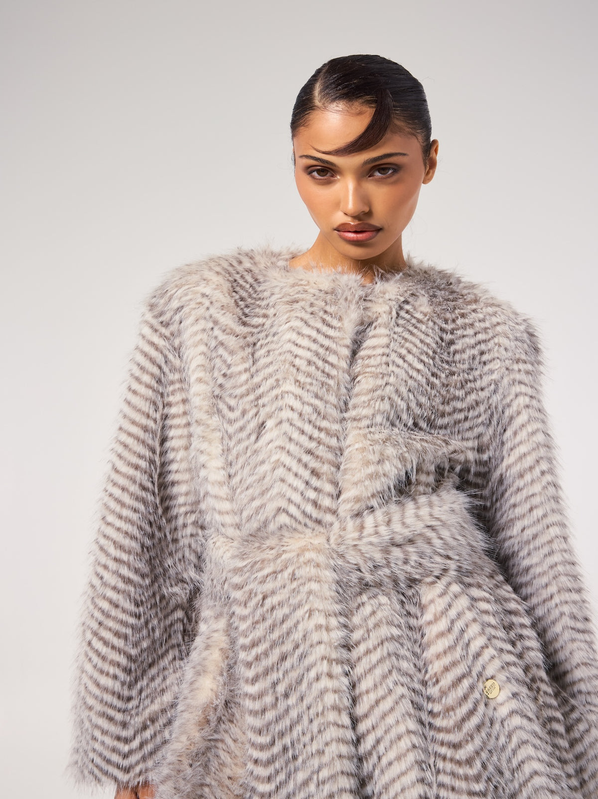 STELLA jacket in Snow Lynx — model wearing a vegan faux fur jacket with a soft striped Snow Lynx pattern and plush texture, creating an elevated cold-weather editorial look.